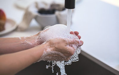 Photograph of a person washing their hands.