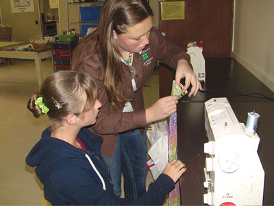 Photograph of two people and a sewing machine.