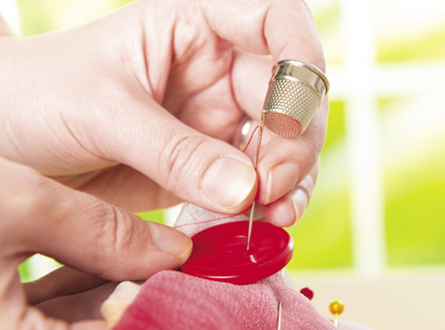 Photo of a button being sewn.