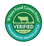 Logo of Where Food Comes From, featuring a green top with a cow silhouette over a field. The word "Verified" is displayed across the center, followed by the website WFCF.CO. The bottom of the circle in teal reads "Non-Hormone Treated Cattle."