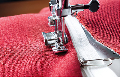 Photograph of a sewing machine sewing a zipper.