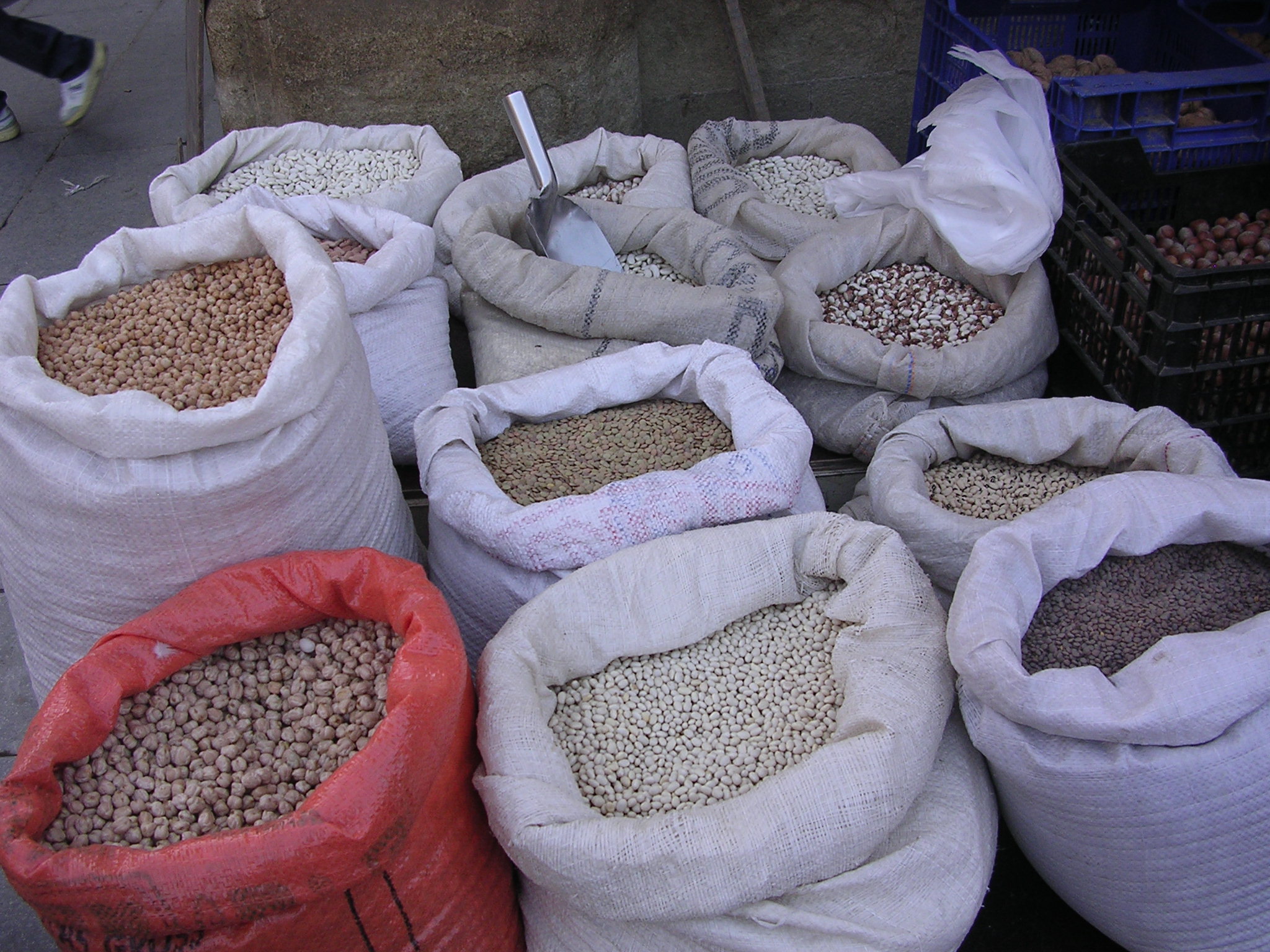 Bags filled with various types of legumes and grains displayed at a market.