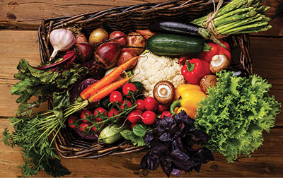 Photograph of various vegetables in a basket.