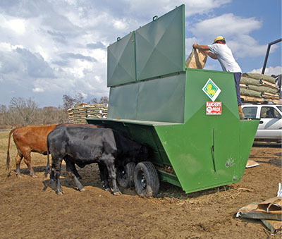 Figure 02: Photograph of a person loading feed into a self-fed supplement delivery system.