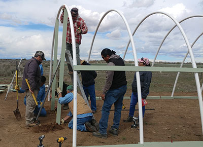 Figure 9: Photograph of people framing the end of the hoop house.