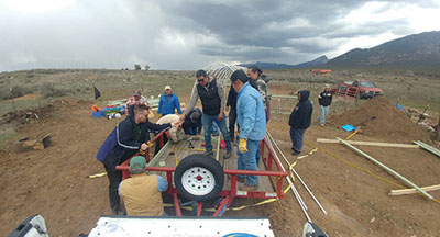 Figure 12: Photograph of people constructing a door frame for the hoop house end.