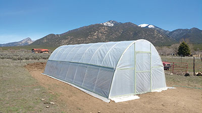 Photograph of a completed high tunnel hoop house structure.