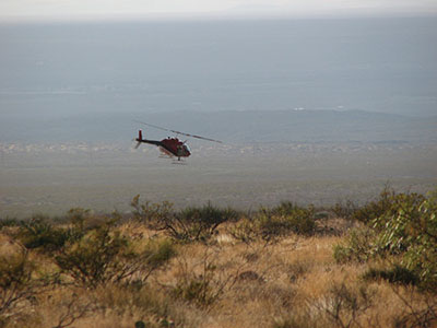 Figure 02: Photograph of a helicopter flying over a desert landscape.