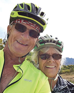 Photograph of a man and a woman wearing bike helmets and cycling clothing.