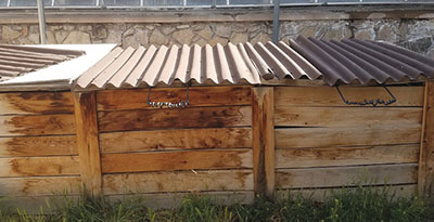 Photograph of a multi-bin wooden compost structure.