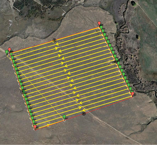 Top-down view of a terrain mapped with parallel survey grid (in yellow, green, and red colors).