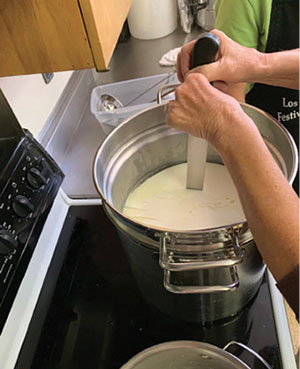 Fig. 01B: Photograph of a person cutting curds.