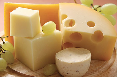 Photograph of various cheeses with grapes.