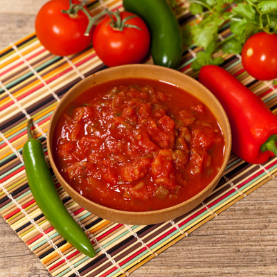 Photo of a bowl of red tomato salsa.