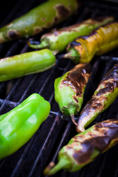 Photograph of green chiles being roasted on a grill.