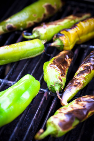 Photo of green chile being roasted on a grill