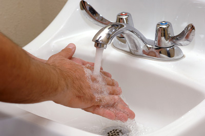 Photo of a man washing his hands.
