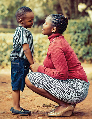Mom kneeling down and listening to her son.