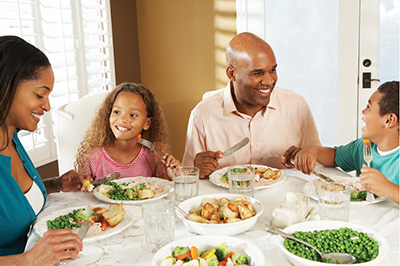 Photograph of a family eating at a table.