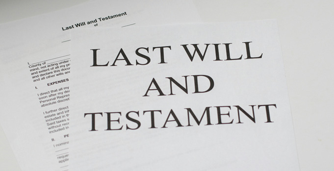 Document titled "Last Will and Testament" on top of additional legal paperwork.