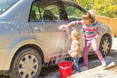 Photograph of two girls washing a car.