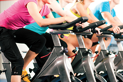 Photograph of a group of people riding spinning machines.