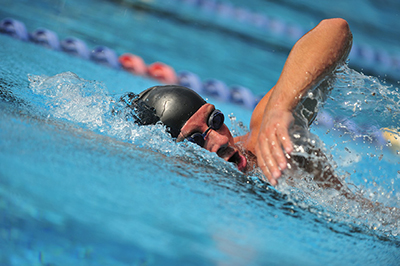 Photograph of a man swimming.