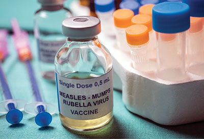 Fig. 01: Photograph of a vial of MMR vaccine and several syringes.