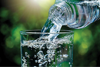 Photograph of a bottle of water being poured into a glass.