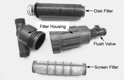 Fig. 4: Photograph showing examples of types of filters used in small plot drip-irrigation systems, including disk filter, screen filter, and filter housing/flush valve.
